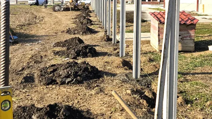 Fence installation: excavations and concrete posts on site