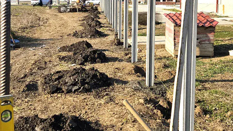 Fence installation: excavations and concrete posts on site
