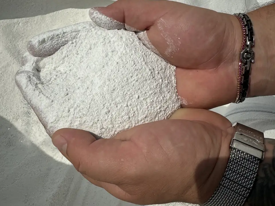 Marble powder from Greece in a hand — one of the raw materials for the premium white panels
