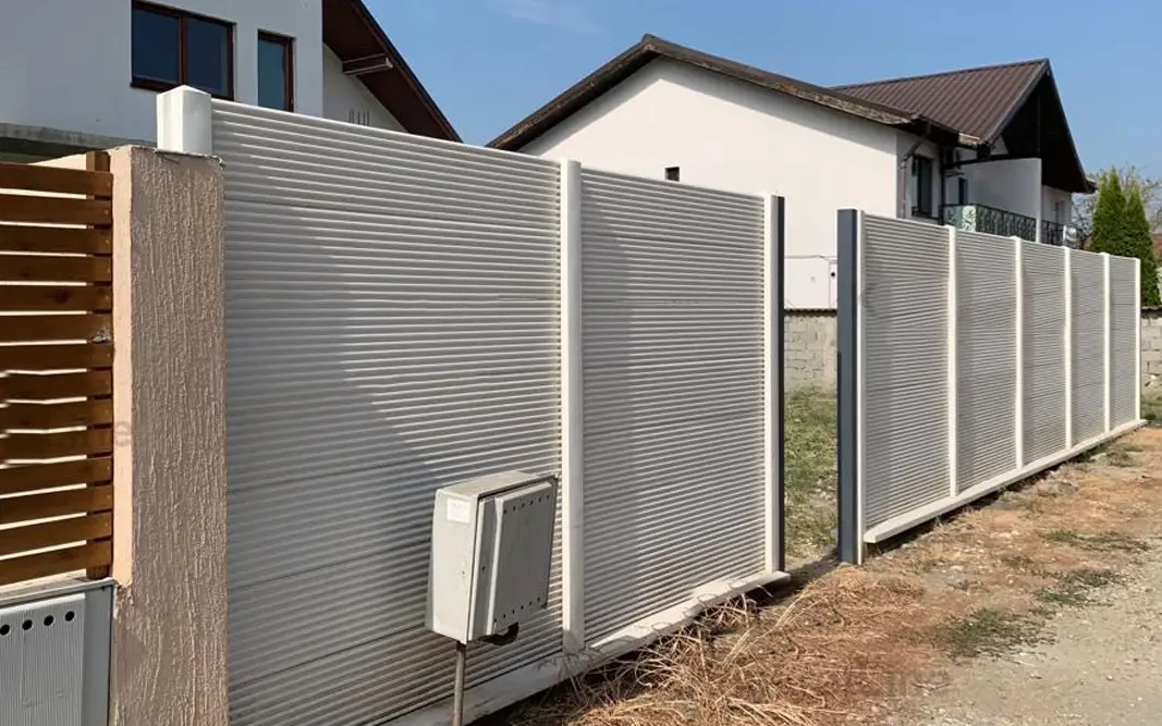 Concrete fence with a fine horizontal relief in front of a house