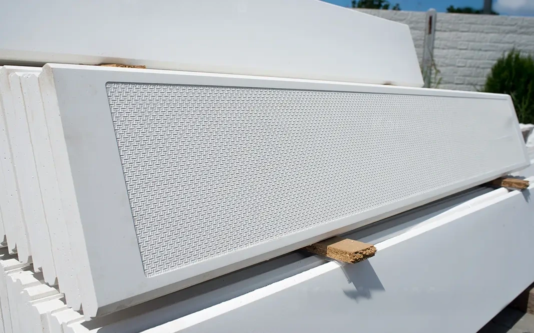 White concrete panels with a fine relief, stacked on top of each other